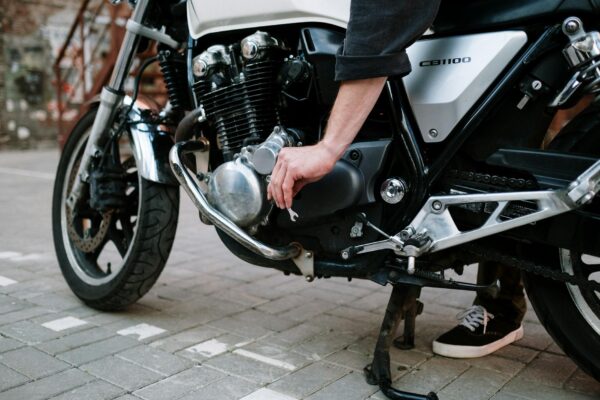 a close up shot of a person using a wrench on a motorcycle